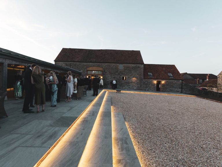 barn wedding reception guests enjoy drinks on terrace